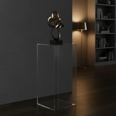 Pedestales en acrílico que exhiben una escultura moderna en un ambiente elegante y contemporáneo.